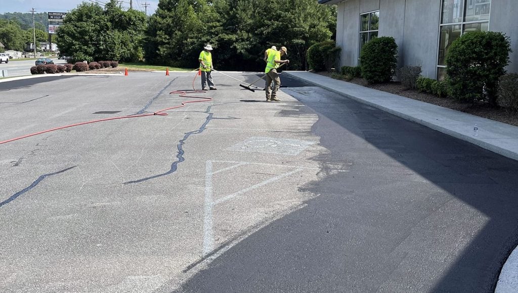 worker completing asphalt sealcoating project