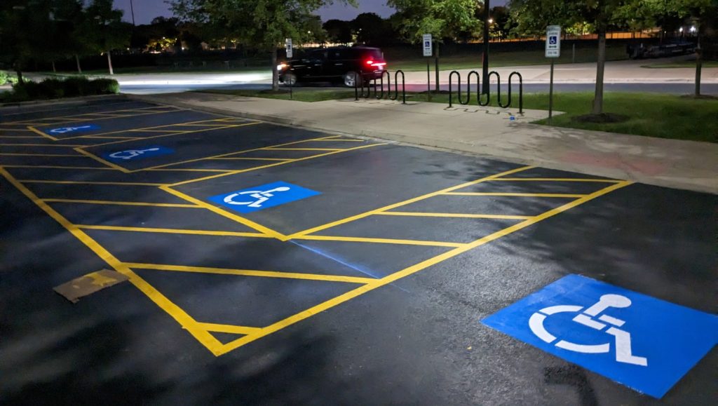 nighttime view of freshly marked ADA-compliant parking stalls and walkways