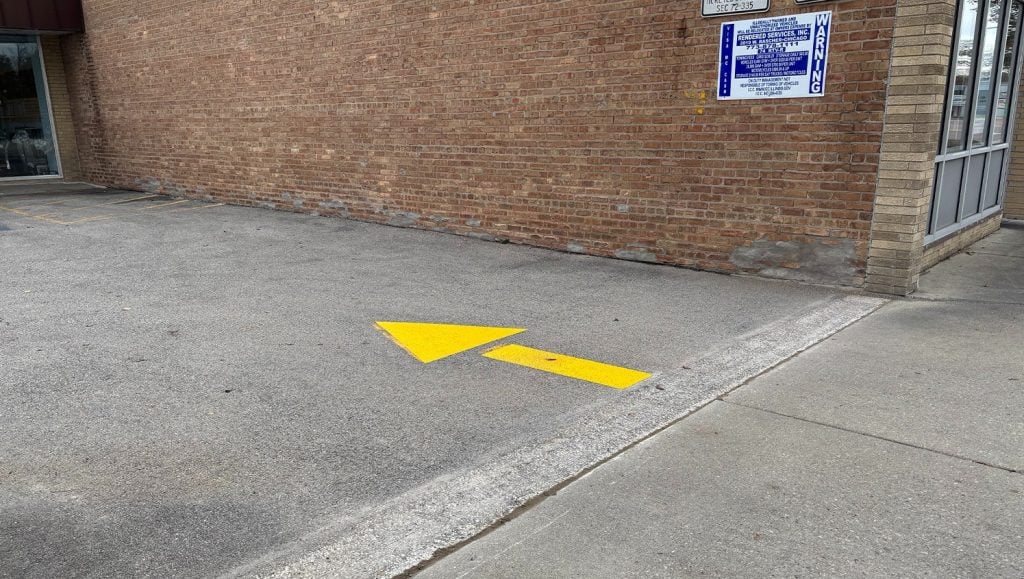 close-up of arrow freshly painted for Dempster Commons Shopping Center