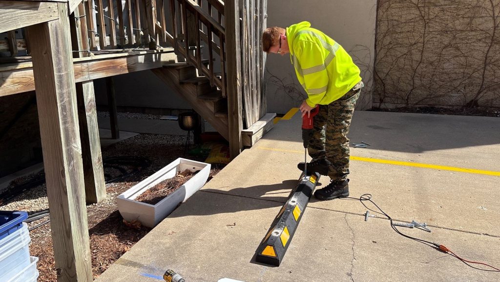 G-FORCE® employee installing new parking lot stop for St. Paul Condominium Association