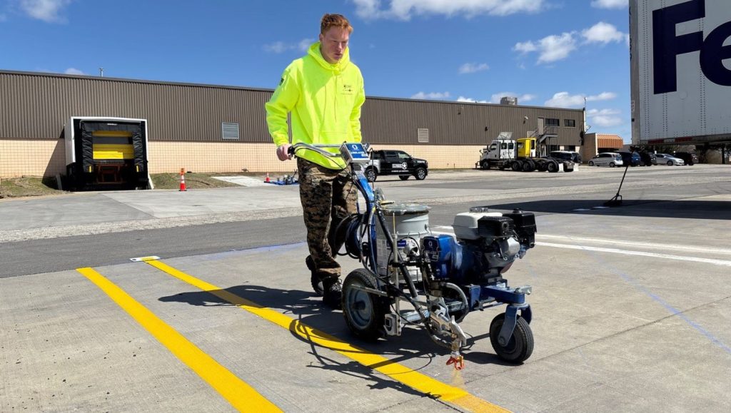 G-FORCE® employee using machine to line stripe FedEx Grounds parking lot