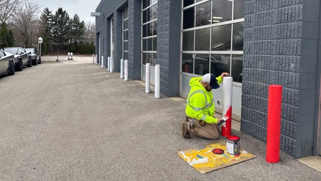 G-FORCE employee painting bollard at Tesla