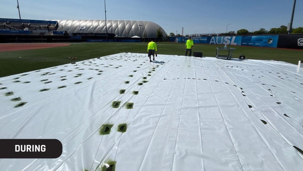 g-force employees installing new logo on athletic field for Athletes Unlimited Softball League