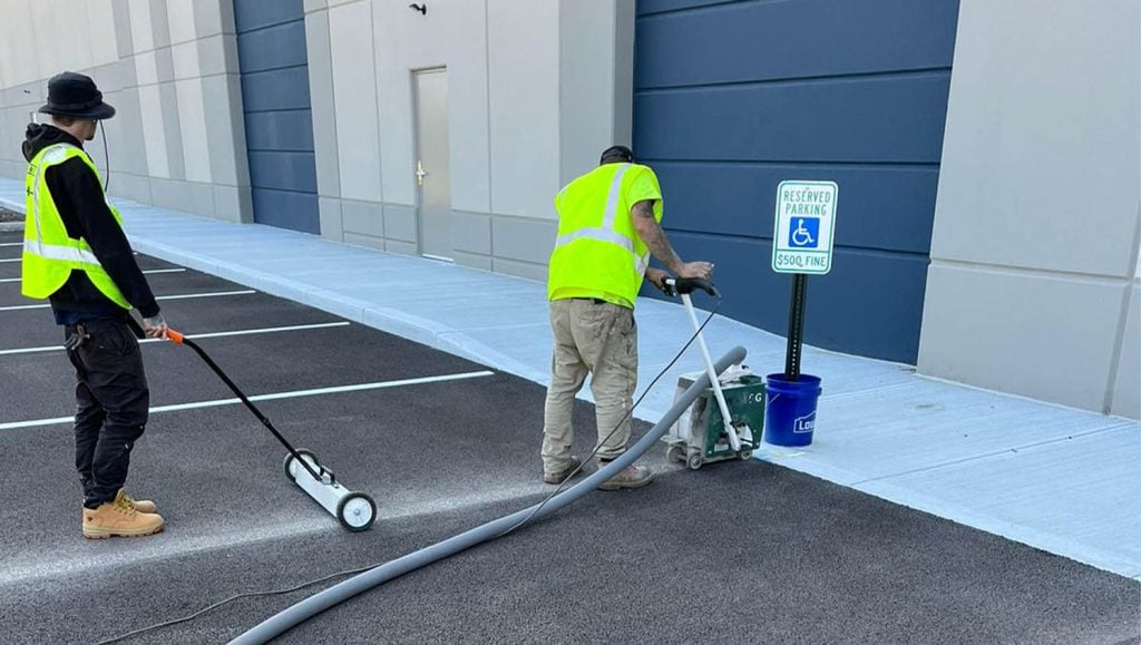 close-up of G-FORCE™ employees grinding Stelzer Road Warehouse parking lot