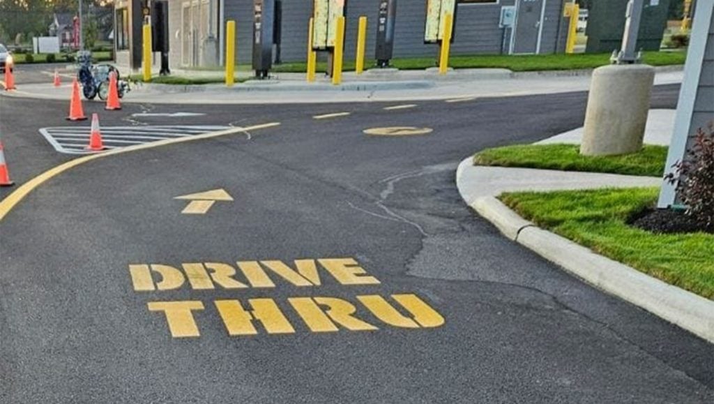 close-up of yellow arrow painted on Mcdonald's parking lot