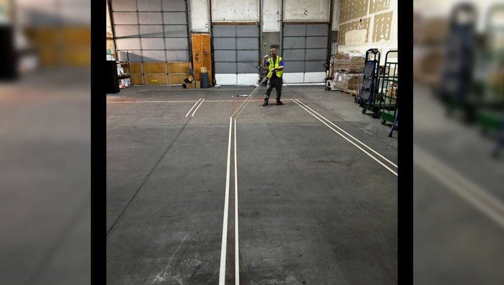 a close view of a G-FORCE employee marking a warehouse