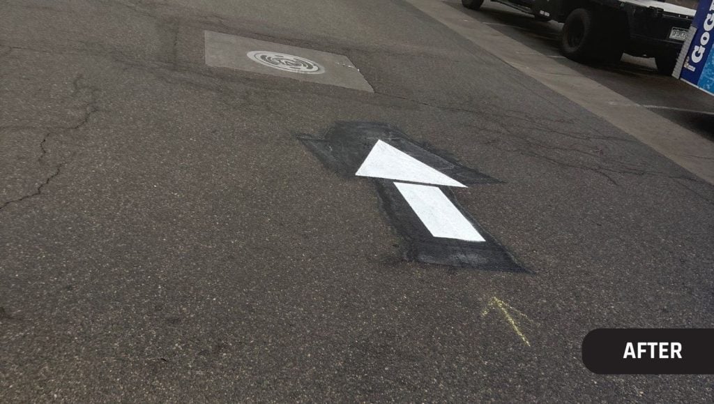 close-up of a white freshly painted arrow for Trader Joe's parking lot