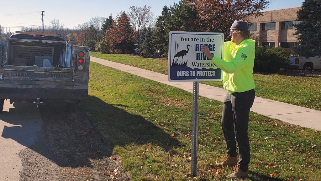 crew member in front of newly installed sign