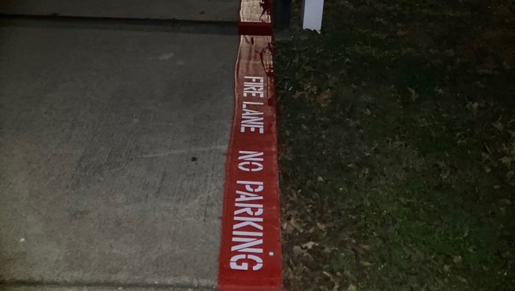 close-up of a freshly painted white arrow for Artistic Motion Dance Academy parking lot