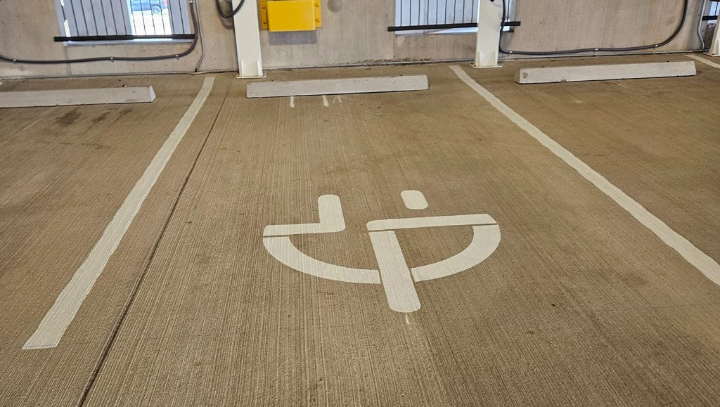 freshly painted ev charging markings for NextEdge parking lot close-up