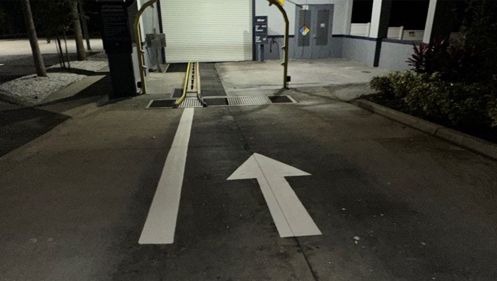 close-up of white arrow freshly painted for Mister Car Wash