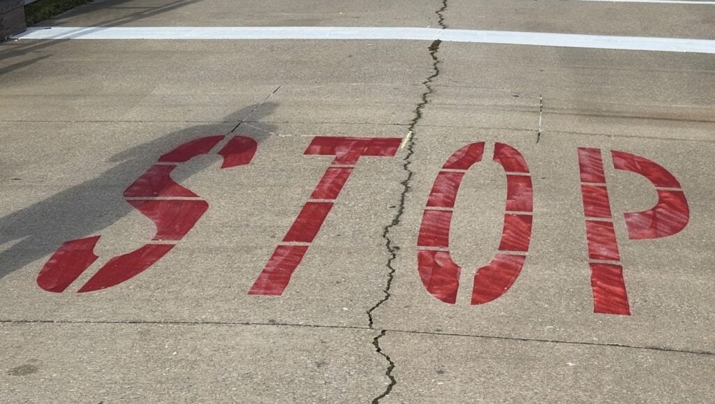 close-up of red line markings freshly painted for Global Maritek parking lot