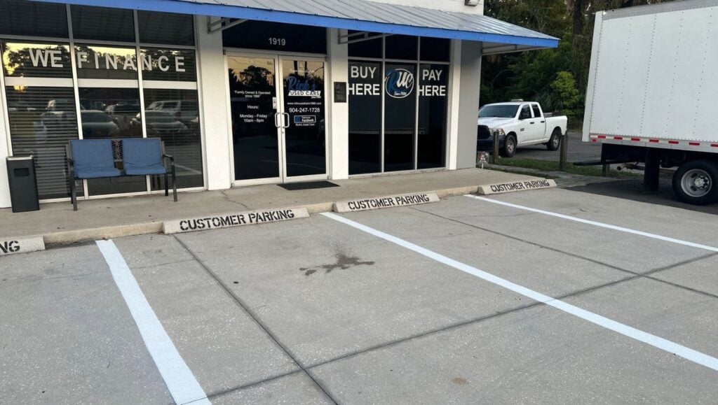 parking spots freshly painted for Rick's Used Cars parking lot