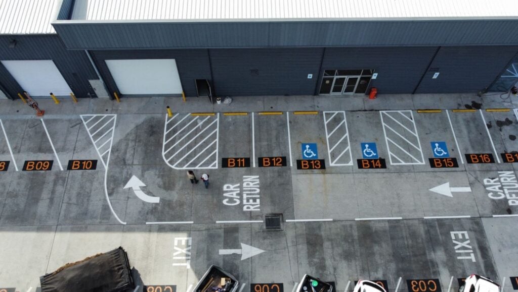 parking spots freshly painted for SIXT Car Rental parking lot aerial view