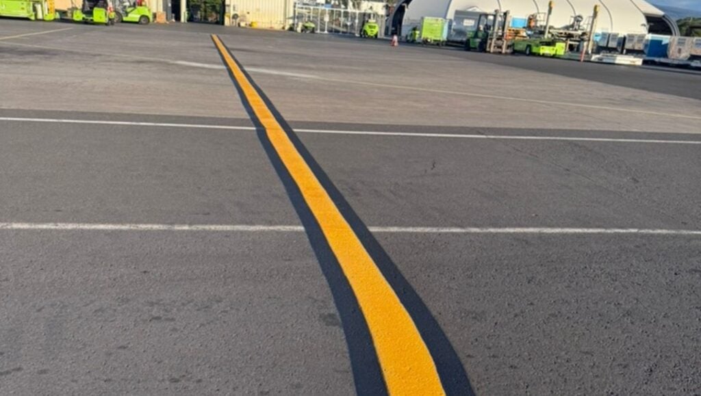 close-up of thick yellow line freshly painted for Traffic Associated Marking Systems
