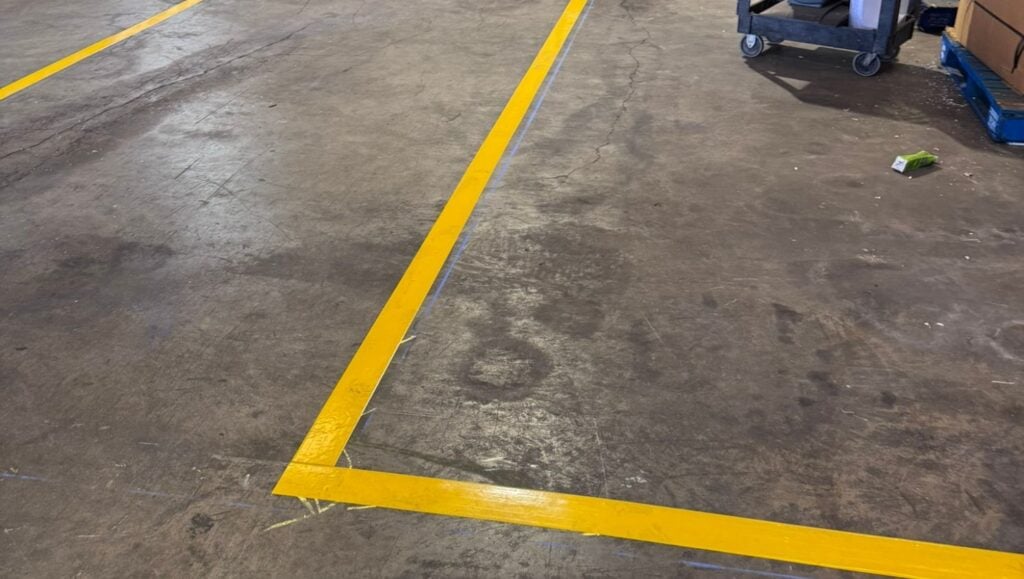 close-up of yellow freshly painted line striping for E-Opala warehouse