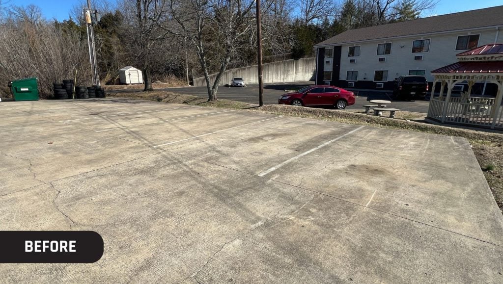 Joy Automotive parking lot with faded line striping and no parking stops
