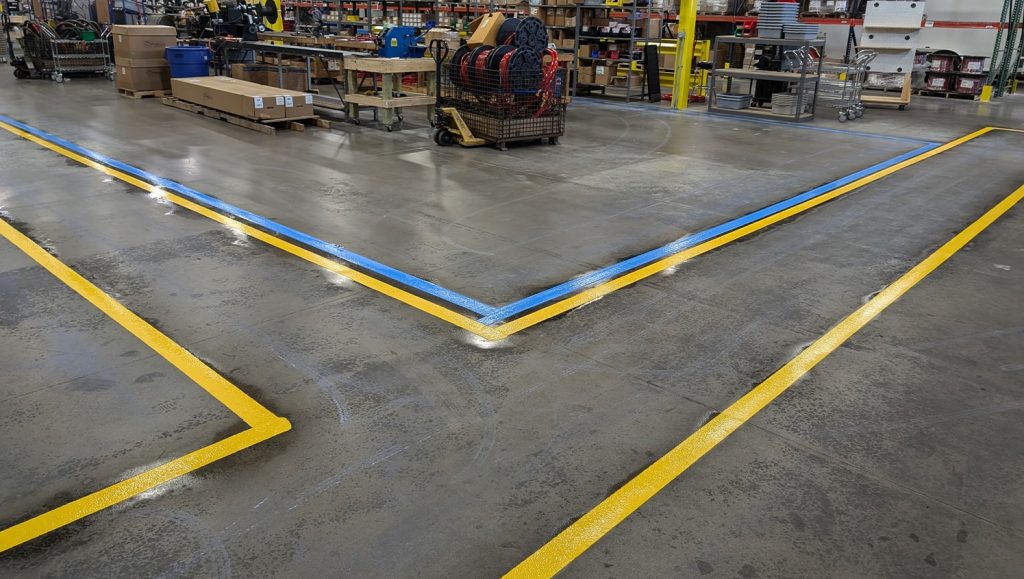 yellow and blue warehouse floor markings freshly painted close-up
