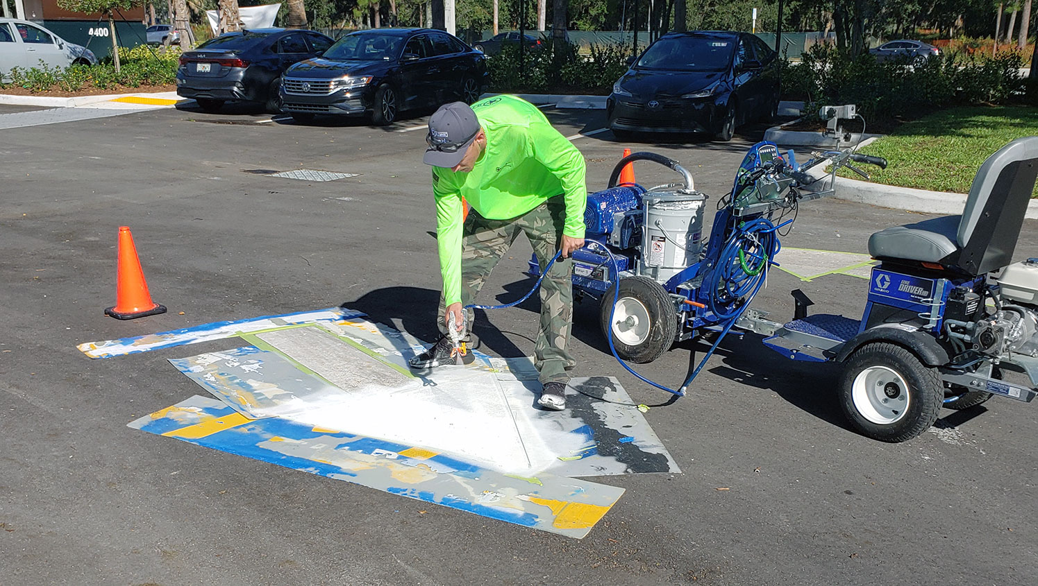 G-FORCE worker applying paint to arrow stencil
