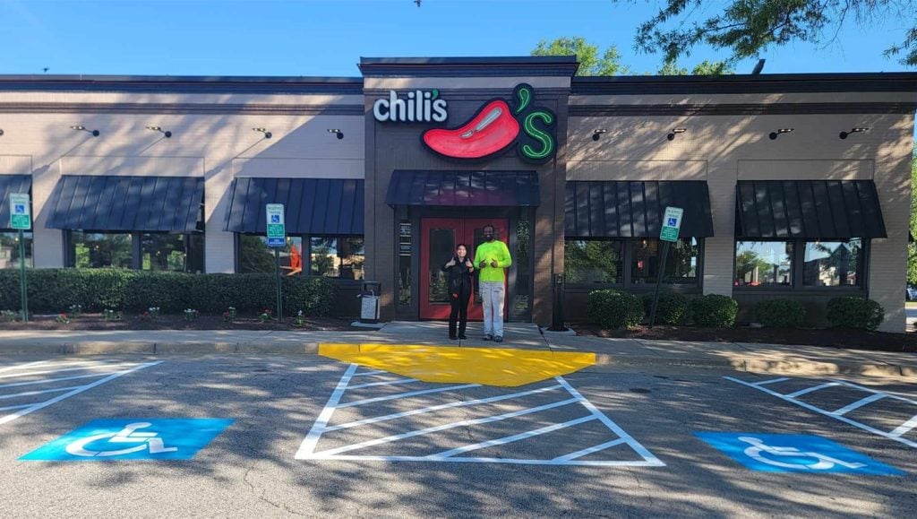 chilis worker and g-force worker smiling in front of chilis