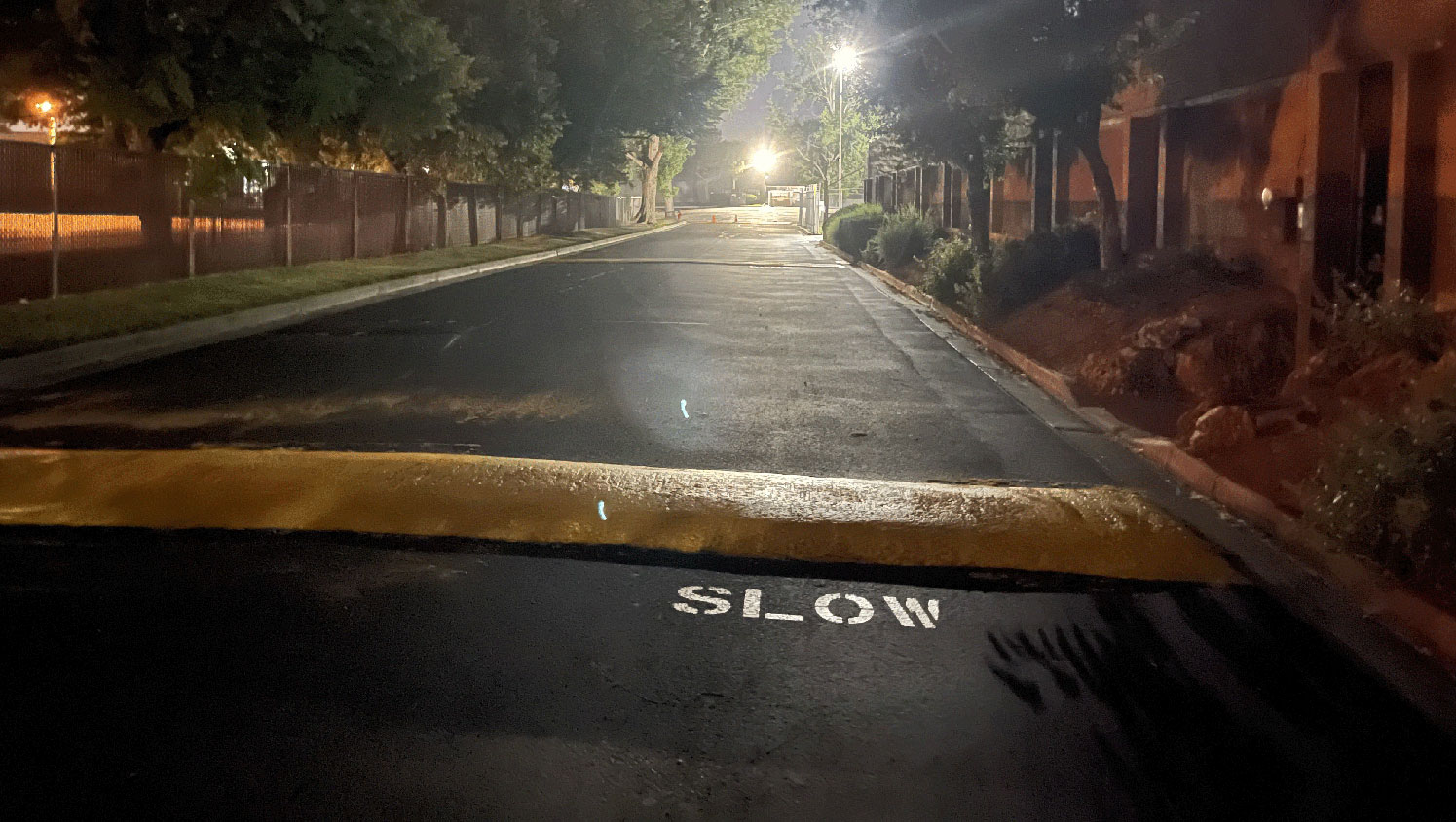 night view of speed bump and slow stencil painted for safety in west valley city, ut