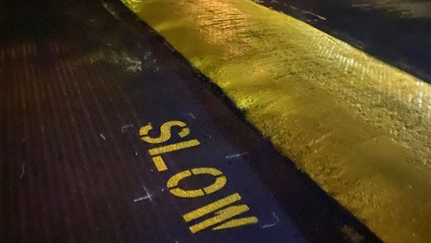 yellow painted speed bump and slow stencil in west valley city, ut