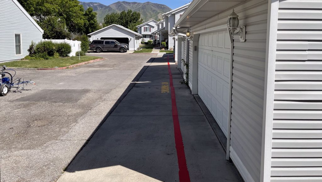 new fire lane curb stripes applied to Millpond Condos pavement in Stansbury Park, UT