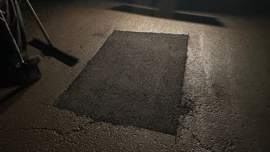 Chevron parking lot with freshly poured asphalt patch
