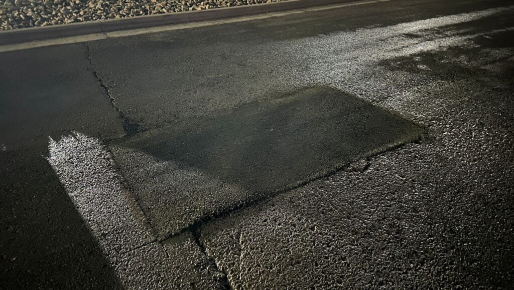 close-up of asphalt patch freshly poured for Chevron