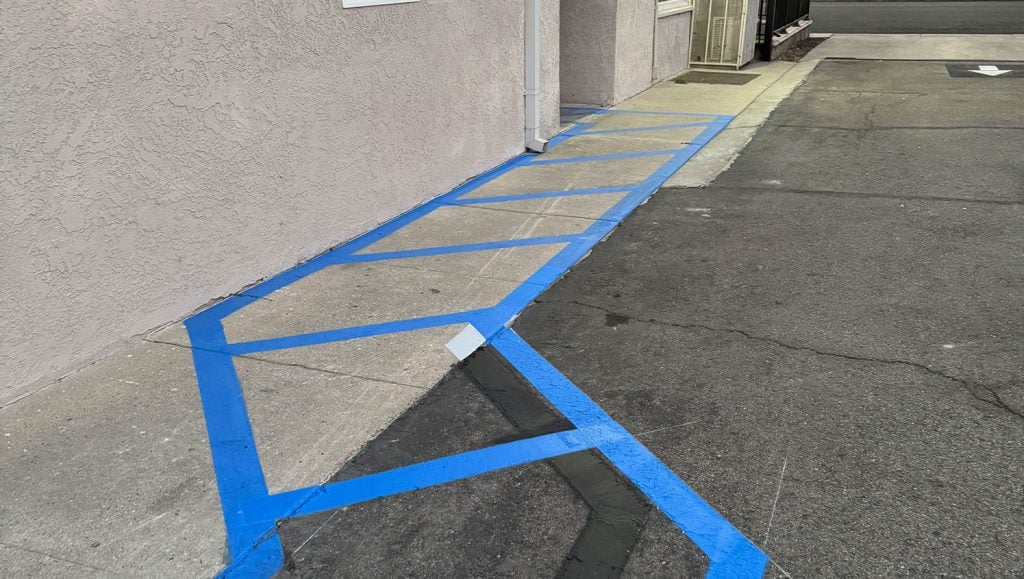 close-up of blue line striping freshly painted for Efficient Home Builders parking lot