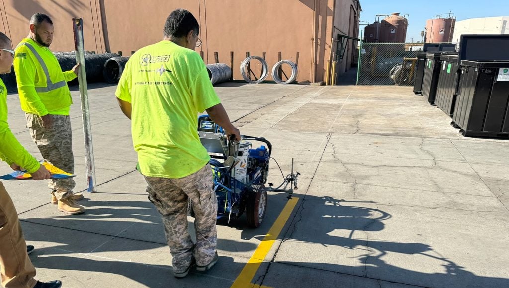 G-FORCE employee using line striping machine