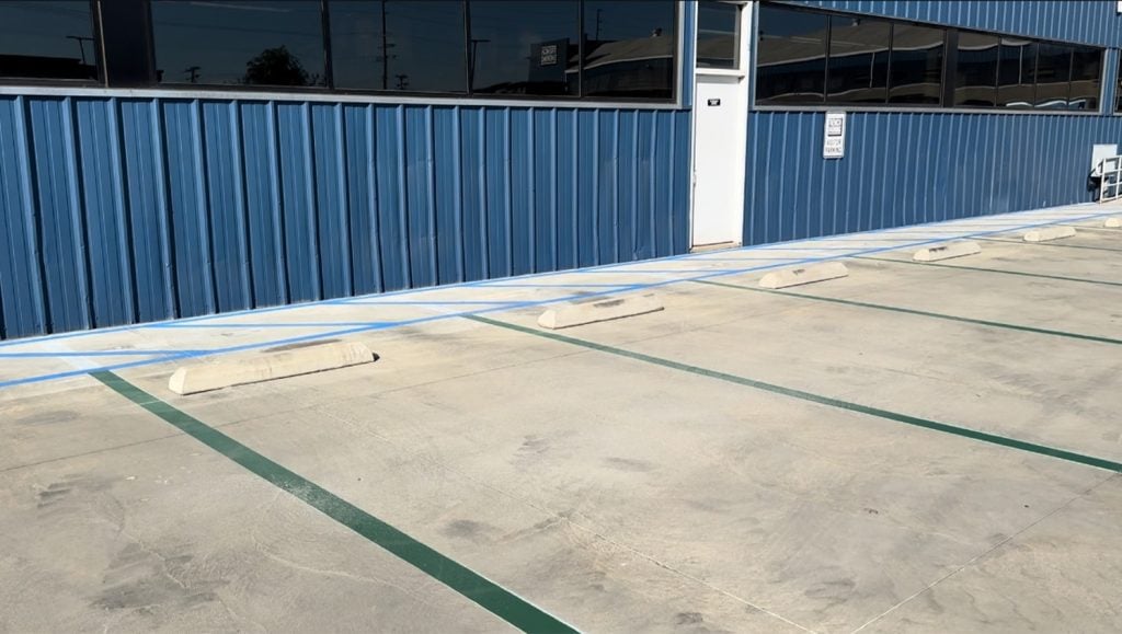 freshly painted blue line markings for Trench Shoring and Reed Thomas Co. parking lot