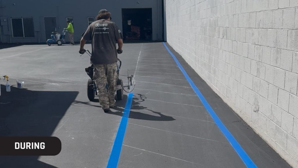g-force employee installing blue line markings for Quantum Freight Logistics parking lot