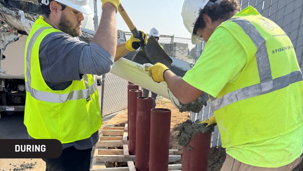 close-up of two employees installing bollards for Holts Renewables