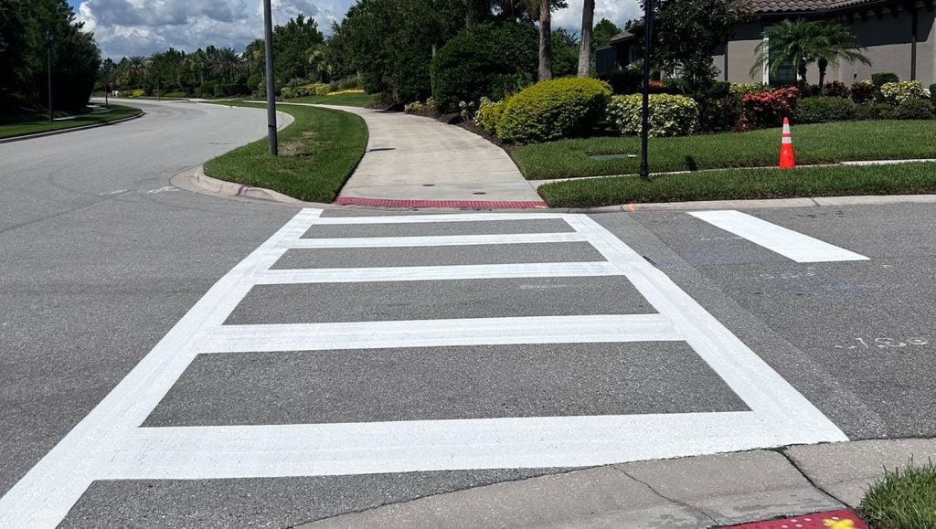 freshly painted crosswalk on pavement in neighborhood