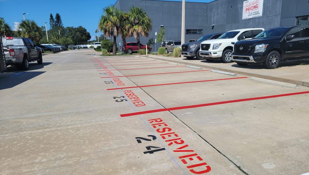 close-up of red line markings freshly painted for Nissan Dealership parking lot