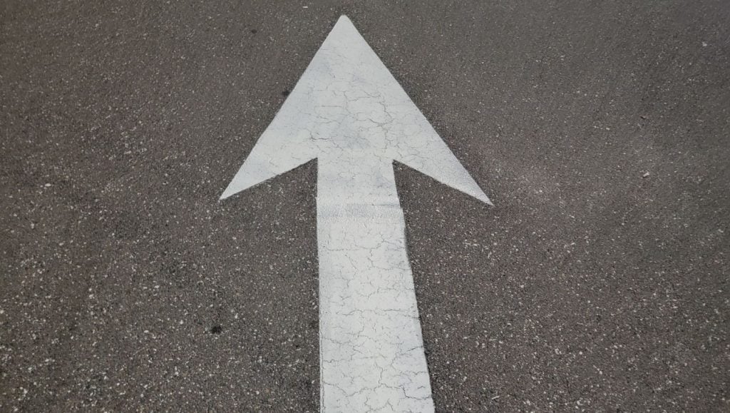single white arrow freshly painted for Goodwill parking lot