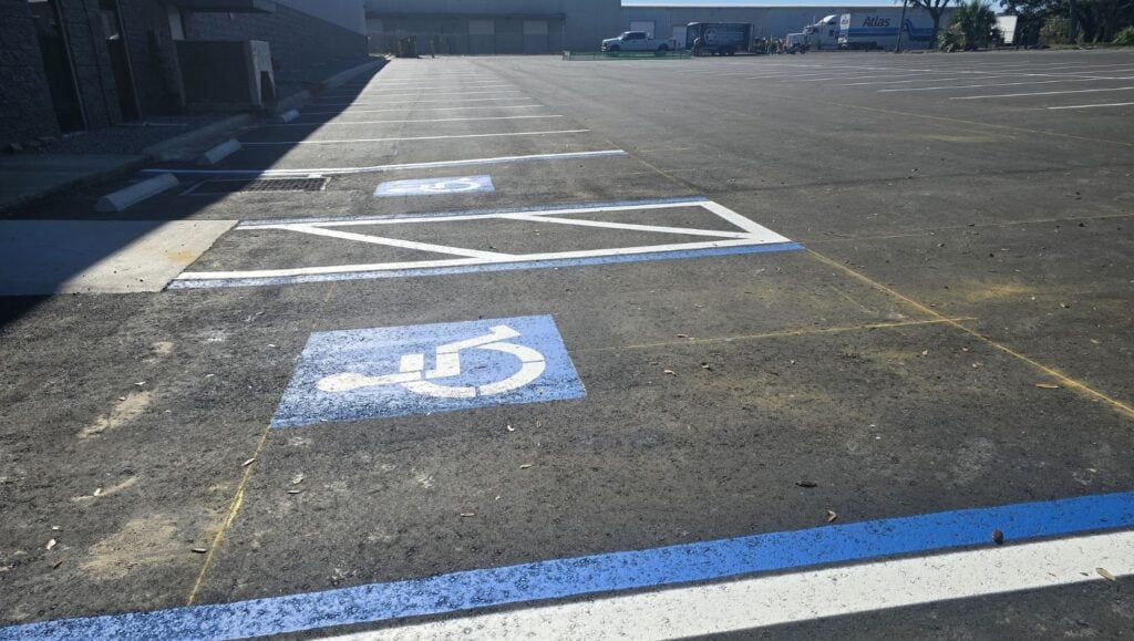 side view of warehouse parking lot with ada compliance parking spots freshly painted