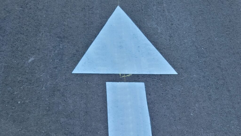 close-up of white arrow freshly painted for Storage Facility parking lot