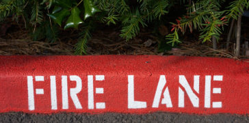 close up of curb painted with fire lane markings