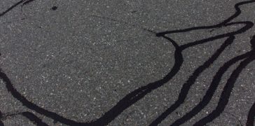 close up of parking lot with crack sealing repairs