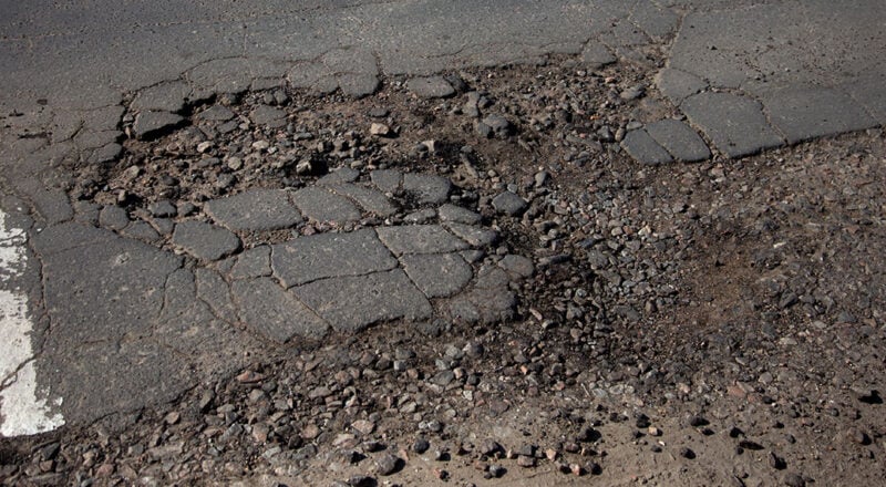 asphalt damaged after winter weather and snow plow
